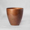 Hand-hammered copper utensil jar center on a grey background