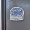This image shows the Deneen magnet on a grey fridge.