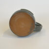 This image shows the color of the clay on the bottom of the mug and the makers mark.