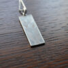 This image shows the 925 hallmark on the back of the Craftsman Rose necklace