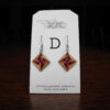 This image shows a close up of Kurt Meyer's earring labeled "D".