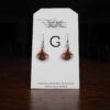 This image shows a close up of Kurt Meyer's earring labeled "G".