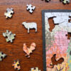 This image a detail of the cow and rooster in the puzzle featuring Julie Leidel's print The Stickley Museum at Craftsman Farms. This image highlights the puzzle, box and carrying bag for the puzzle pieces.