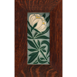 This image shows a white peony with a yellow center in the top third of the ceramic tile. The rest of the tile is filled with sprawling green leaves. The tile has a light blue background and is in a brown oak frame.
