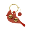 Leather red cardinal with two brass sleigh bells attached. The leather hangs from a brass ring that can be hung on a door knob.