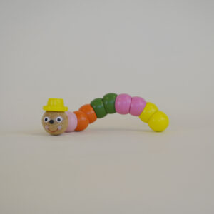 Wooden worm with pink, orange, green and yellow segmented body parts, wearing a yellow top hat.