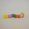 Back of the wooden worm with pink, orange, green and yellow segmented body parts, wearing a yellow top hat.